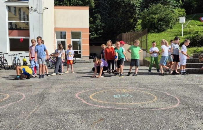 Dziś uczniowie klasy 2b wybrali się na plac przed szkołę, gdzie połączyli przyjemne z pożytecznym. Podczas zabawy w rzuty woreczkiem do celu dzieci nie tylko świetnie się bawiły, ale również ćwiczyły swoją sprawność rachunkową – dodając zdobyte przez grupy punkty.  Radość, ruch i nauka w jednym – właśnie tak lubimy się uczyć.