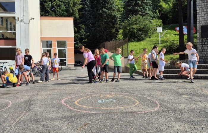 Dziś uczniowie klasy 2b wybrali się na plac przed szkołę, gdzie połączyli przyjemne z pożytecznym. Podczas zabawy w rzuty woreczkiem do celu dzieci nie tylko świetnie się bawiły, ale również ćwiczyły swoją sprawność rachunkową – dodając zdobyte przez grupy punkty.  Radość, ruch i nauka w jednym – właśnie tak lubimy się uczyć.