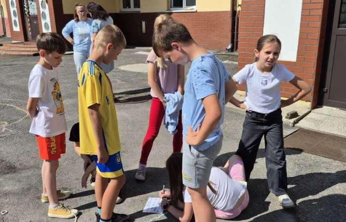 Dziś uczniowie klasy 2b wybrali się na plac przed szkołę, gdzie połączyli przyjemne z pożytecznym. Podczas zabawy w rzuty woreczkiem do celu dzieci nie tylko świetnie się bawiły, ale również ćwiczyły swoją sprawność rachunkową – dodając zdobyte przez grupy punkty.  Radość, ruch i nauka w jednym – właśnie tak lubimy się uczyć.