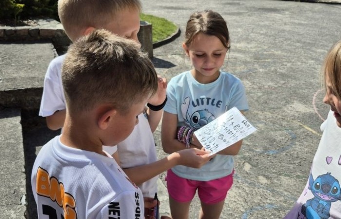 Dziś uczniowie klasy 2b wybrali się na plac przed szkołę, gdzie połączyli przyjemne z pożytecznym. Podczas zabawy w rzuty woreczkiem do celu dzieci nie tylko świetnie się bawiły, ale również ćwiczyły swoją sprawność rachunkową – dodając zdobyte przez grupy punkty.  Radość, ruch i nauka w jednym – właśnie tak lubimy się uczyć.