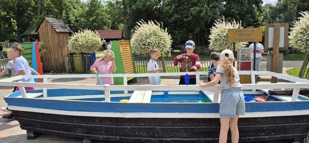 17 czerwca uczniowie klas drugich mieli okazję spędzić niezapomniany dzień w malowniczej Zagrodzie Kociewskiej. Program wycieczki obfitował w atrakcje, a jedną z najciekawszych były kreatywne warsztaty emalierskie. Dzieci dowiedziały się, czym jest emalia i jak powstają naczynia emaliowane. W części praktycznej każdy uczestnik mógł samodzielnie ozdobić ceramiczny magnes przy użyciu specjalnych markerów. Powstały w ten sposób wyjątkowe, kolorowe prace – prawdziwe małe dzieła sztuki, które będą piękną pamiątką na lata. Po warsztatach przyszedł czas na relaks i zabawę. Uczniowie korzystali z uroków otoczenia – bawili się na świeżym powietrzu, zwiedzali zagrodę i dokarmiali zwierzęta. Szerokie uśmiechy na twarzach dzieci, gdy wracały do szkoły, były najlepszym dowodem na to, że wyjazd był udany.