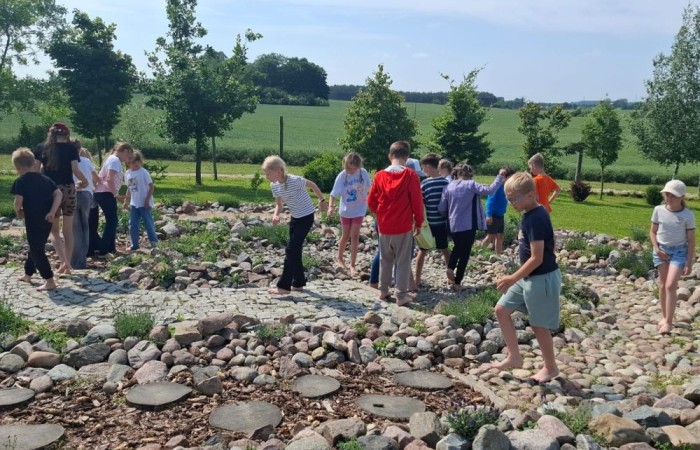 17 czerwca uczniowie klas drugich mieli okazję spędzić niezapomniany dzień w malowniczej Zagrodzie Kociewskiej. Program wycieczki obfitował w atrakcje, a jedną z najciekawszych były kreatywne warsztaty emalierskie. Dzieci dowiedziały się, czym jest emalia i jak powstają naczynia emaliowane. W części praktycznej każdy uczestnik mógł samodzielnie ozdobić ceramiczny magnes przy użyciu specjalnych markerów. Powstały w ten sposób wyjątkowe, kolorowe prace – prawdziwe małe dzieła sztuki, które będą piękną pamiątką na lata. Po warsztatach przyszedł czas na relaks i zabawę. Uczniowie korzystali z uroków otoczenia – bawili się na świeżym powietrzu, zwiedzali zagrodę i dokarmiali zwierzęta. Szerokie uśmiechy na twarzach dzieci, gdy wracały do szkoły, były najlepszym dowodem na to, że wyjazd był udany.
