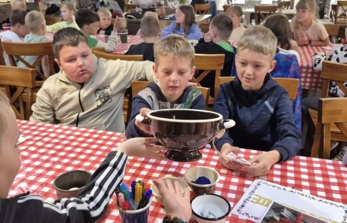 17 czerwca uczniowie klas drugich mieli okazję spędzić niezapomniany dzień w malowniczej Zagrodzie Kociewskiej. Program wycieczki obfitował w atrakcje, a jedną z najciekawszych były kreatywne warsztaty emalierskie. Dzieci dowiedziały się, czym jest emalia i jak powstają naczynia emaliowane. W części praktycznej każdy uczestnik mógł samodzielnie ozdobić ceramiczny magnes przy użyciu specjalnych markerów. Powstały w ten sposób wyjątkowe, kolorowe prace – prawdziwe małe dzieła sztuki, które będą piękną pamiątką na lata. Po warsztatach przyszedł czas na relaks i zabawę. Uczniowie korzystali z uroków otoczenia – bawili się na świeżym powietrzu, zwiedzali zagrodę i dokarmiali zwierzęta. Szerokie uśmiechy na twarzach dzieci, gdy wracały do szkoły, były najlepszym dowodem na to, że wyjazd był udany.