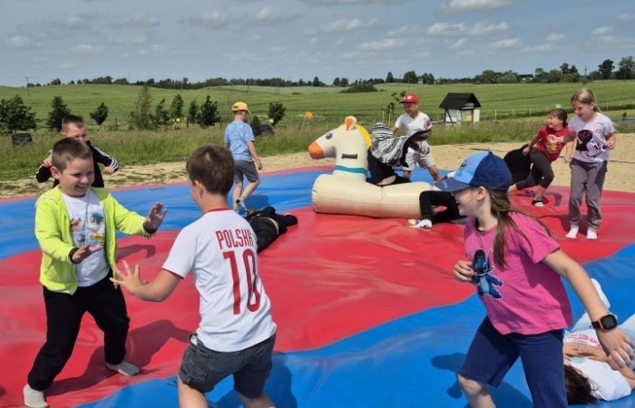 17 czerwca uczniowie klas drugich mieli okazję spędzić niezapomniany dzień w malowniczej Zagrodzie Kociewskiej. Program wycieczki obfitował w atrakcje, a jedną z najciekawszych były kreatywne warsztaty emalierskie. Dzieci dowiedziały się, czym jest emalia i jak powstają naczynia emaliowane. W części praktycznej każdy uczestnik mógł samodzielnie ozdobić ceramiczny magnes przy użyciu specjalnych markerów. Powstały w ten sposób wyjątkowe, kolorowe prace – prawdziwe małe dzieła sztuki, które będą piękną pamiątką na lata. Po warsztatach przyszedł czas na relaks i zabawę. Uczniowie korzystali z uroków otoczenia – bawili się na świeżym powietrzu, zwiedzali zagrodę i dokarmiali zwierzęta. Szerokie uśmiechy na twarzach dzieci, gdy wracały do szkoły, były najlepszym dowodem na to, że wyjazd był udany.