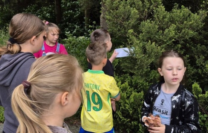 W ramach projektu S.Z.U.M. nasi najmłodsi uczniowie z klas 1-3 wzięli udział w wyjątkowej zabawie edukacyjnej – podchodach ekologicznych. Na terenie szkoły czekały na nich liczne zadania, które nie tylko dostarczyły mnóstwo radości, ale również uczyły, jak dbać o naszą planetę. Dzieci m.in.: rozwiązywały zagadki przyrodnicze, przytulały drzewa, poszukiwały ukrytych figurek zwierząt, wspólnie śpiewały piosenkę o Ziemi, zapisywały ekologiczne hasła – jak pomagać planecie, pokonywały tor przeszkód z ekologicznym przesłaniem. Było radośnie, aktywnie i bardzo zielono.