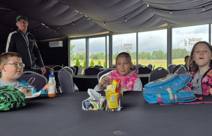 Choć pogoda nie do końca dopisała, uczniowie klasy 2b spędzili niezwykle ciekawy dzień w Sand Valley Golf Resort w Pasłęku. Dzieci miały okazję: dowiedzieć się, na czym polega gra w golfa, obejrzeć profesjonalny sprzęt wykorzystywany w tym sporcie, przejechać się meleksem po rozległym terenie, spróbować pysznych frytek i orzeźwiającej lemoniady serwowanych w tutejszej restauracji. Na zakończenie każdy uczestnik otrzymał pamiątkowy medal, piłeczkę golfową i drobne upominki. Niestety, z powodu deszczu nie udało się przeprowadzić treningu uderzeń piłeczki… ale kto wie – może następnym razem pogoda będzie łaskawsza.