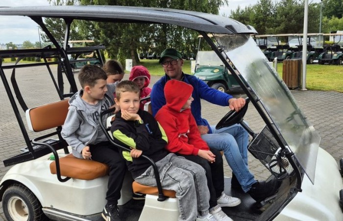 Choć pogoda nie do końca dopisała, uczniowie klasy 2b spędzili niezwykle ciekawy dzień w Sand Valley Golf Resort w Pasłęku. Dzieci miały okazję: dowiedzieć się, na czym polega gra w golfa, obejrzeć profesjonalny sprzęt wykorzystywany w tym sporcie, przejechać się meleksem po rozległym terenie, spróbować pysznych frytek i orzeźwiającej lemoniady serwowanych w tutejszej restauracji. Na zakończenie każdy uczestnik otrzymał pamiątkowy medal, piłeczkę golfową i drobne upominki. Niestety, z powodu deszczu nie udało się przeprowadzić treningu uderzeń piłeczki… ale kto wie – może następnym razem pogoda będzie łaskawsza.