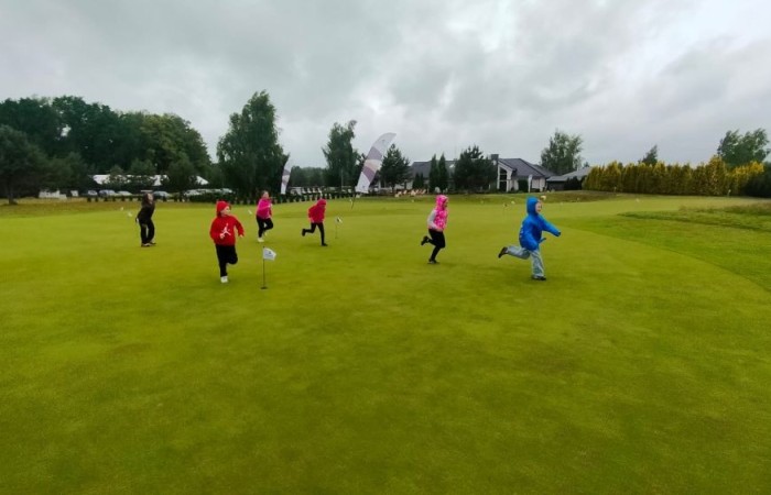 Choć pogoda nie do końca dopisała, uczniowie klasy 2b spędzili niezwykle ciekawy dzień w Sand Valley Golf Resort w Pasłęku. Dzieci miały okazję: dowiedzieć się, na czym polega gra w golfa, obejrzeć profesjonalny sprzęt wykorzystywany w tym sporcie, przejechać się meleksem po rozległym terenie, spróbować pysznych frytek i orzeźwiającej lemoniady serwowanych w tutejszej restauracji. Na zakończenie każdy uczestnik otrzymał pamiątkowy medal, piłeczkę golfową i drobne upominki. Niestety, z powodu deszczu nie udało się przeprowadzić treningu uderzeń piłeczki… ale kto wie – może następnym razem pogoda będzie łaskawsza.