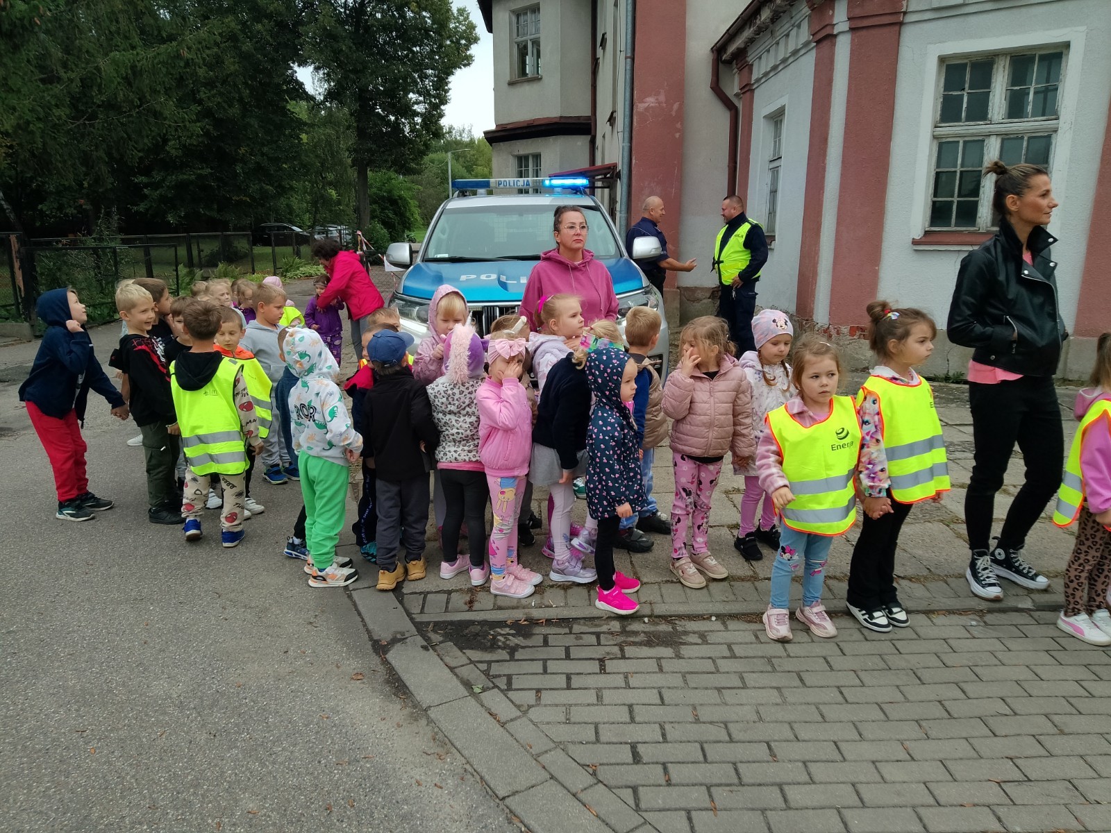 Dzieci z grup starszych Sówki, Leśne skrzaty oraz Biedronki odwiedzili funkcjonariusze policji drogowej , którzy przeprowadzili zajęcia edukacyjne na temat bezpieczeństwa w ruchu ulicznym. Wydarzenie odbyło się w ramach zajęć ,,Moja droga do przedszkola”, której celem jest kształtowanie prawidłowych nawyków i świadomości wśród najmłodszych uczestników ruchu drogowego. Policjanci opowiedzieli przedszkolakom o zasadach bezpiecznego przechodzenia przez jezdnię, znaczeniu znaków drogowych. Dzieci dowiedziały się również, dlaczego ważne jest noszenie odblasków, zwłaszcza jesienią i zimą, gdy wcześniej zapada zmrok.                                
Takie spotkania są bardzo ważne. Dzieci w tym wieku chłoną wiedzę jak gąbka.                  Warto więc już teraz uczyć je zasad, które mogą uratować życie. Przedszkolaki pożegnały policjanta gromkimi brawami i obiecały zawsze pamiętać o zasadach bezpieczeństwa.
Spotkanie z policjantem było nie tylko cenną lekcją, ale też okazją do wzbudzenia w dzieciach zaufania do funkcjonariuszy. To ważny krok w budowaniu poczucia bezpieczeństwa od najmłodszych lat.

