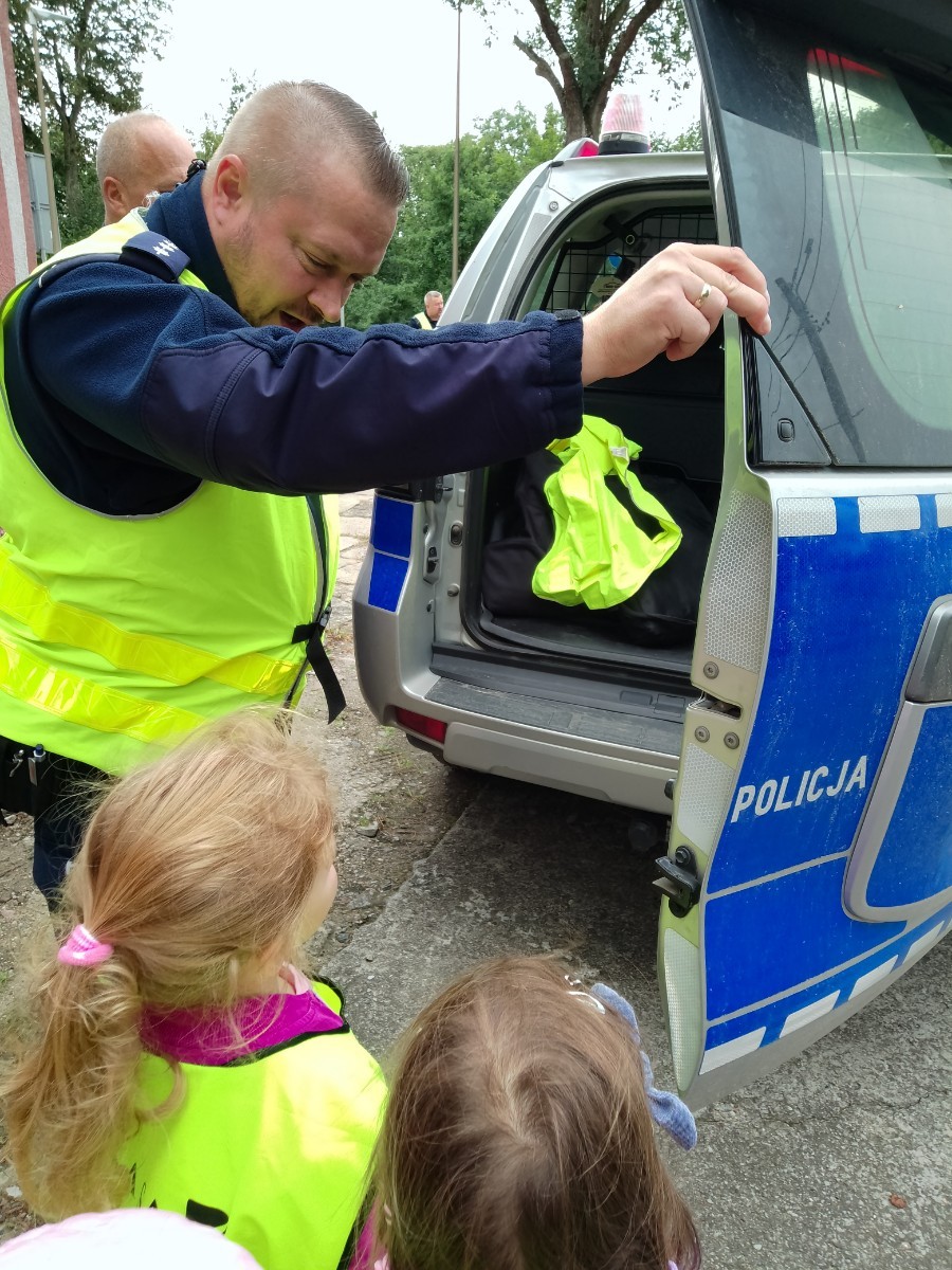 Dzieci z grup starszych Sówki, Leśne skrzaty oraz Biedronki odwiedzili funkcjonariusze policji drogowej , którzy przeprowadzili zajęcia edukacyjne na temat bezpieczeństwa w ruchu ulicznym. Wydarzenie odbyło się w ramach zajęć ,,Moja droga do przedszkola”, której celem jest kształtowanie prawidłowych nawyków i świadomości wśród najmłodszych uczestników ruchu drogowego. Policjanci opowiedzieli przedszkolakom o zasadach bezpiecznego przechodzenia przez jezdnię, znaczeniu znaków drogowych. Dzieci dowiedziały się również, dlaczego ważne jest noszenie odblasków, zwłaszcza jesienią i zimą, gdy wcześniej zapada zmrok.                                
Takie spotkania są bardzo ważne. Dzieci w tym wieku chłoną wiedzę jak gąbka.                  Warto więc już teraz uczyć je zasad, które mogą uratować życie. Przedszkolaki pożegnały policjanta gromkimi brawami i obiecały zawsze pamiętać o zasadach bezpieczeństwa.
Spotkanie z policjantem było nie tylko cenną lekcją, ale też okazją do wzbudzenia w dzieciach zaufania do funkcjonariuszy. To ważny krok w budowaniu poczucia bezpieczeństwa od najmłodszych lat.
