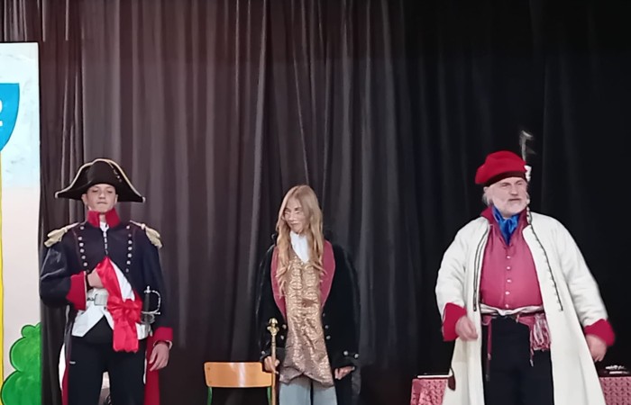 Każdego roku uczniowie naszej szkoły mają niepowtarzalną okazję wziąć udział w wyjątkowym wydarzeniu edukacyjnym - ŻYWEJ LEKCJI HISTORII, prowadzonej przez grupę rekonstrukcyjną Chorągiew Komturstwa Gniewskiego. To spotkanie, które na długo pozostaje w pamięci uczestników, łącząc wiedzę historyczną z emocjami, ruchem i bezpośrednim kontaktem z przeszłością.
W tym roku tematyka spotkań została zrealizowana na dwóch poziomach wiekowych:
Klasy 4-6: Świat starożytnych Greków i Rzymian
Uczniowie klas młodszych przenieśli się do czasów starożytności - epoki potężnych cywilizacji, mitologii, igrzysk olimpijskich i legionów rzymskich. Dzięki strojom z epoki, realistycznym rekwizytom i barwnym opowieściom rekonstruktorów, dzieci mogły poczuć atmosferę antycznego świata. Dowiedzieli się, jak wyglądało życie codzienne Greków i Rzymian, jakie były zwyczaje wojenne, a nawet jak wyglądały ćwiczenia wojskowe legionistów. Zajęcia - prowadzone w formie interaktywnej - dały uczniom możliwość przymierzenia elementów uzbrojenia oraz wzięcia udziału w krótkich pokazach.
Klasy 7-8: Długi wiek XIX
Starsze klasy uczestniczyły w lekcji poświęconej Długiemu wiekowi XIX, czyli okresowi, który ukształtował współczesny świat. Rekonstruktorzy przybliżyli wydarzenia związane z rewolucjami, walką o niepodległość, przemianami społecznymi i narodzinami nowoczesnych idei. Szczególną uwagę poświęcono wydarzeniom ważnym dla Polski - rozbiorom, powstaniom narodowym i postaciom kluczowym dla naszej historii. Uczniowie mogli zobaczyć repliki broni, a także stroje z XIX wieku. Dla wielu była to okazja do poznania historii w sposób bardziej angażujący niż podręcznik - przez opowieści, prezentacje multimedialne i inscenizacje.
Żywa lekcja historii to nie tylko atrakcja, ale przede wszystkim cenna forma nauki. Bezpośredni kontakt z pasjonatami historii oraz aktywne uczestnictwo w przedsięwzięciu sprawia, że uczniowie lepiej zapamiętują materiał, rozbudzają swoją ciekawość i rozwijają szacunek do dziedzictwa kulturowego.