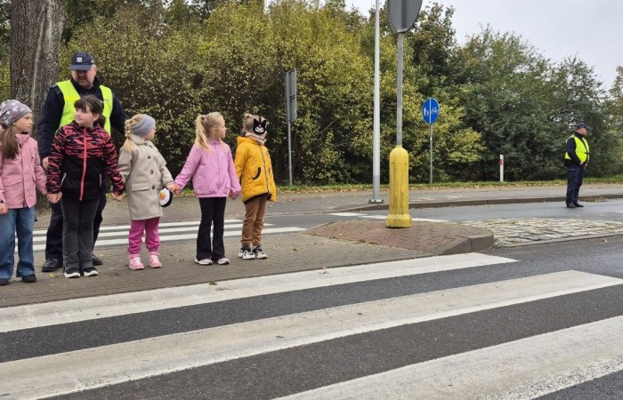 W październiku w naszej szkole odbyły się spotkania uczniów klas I–III z policjantami z Komisariatu Policji w Pasłęku. Podczas zajęć dzieci rozmawiały z funkcjonariuszami o bezpieczeństwie na drodze, uczyły się, jak prawidłowo zachowywać się na przejściu dla pieszych oraz jakie zasady są najważniejsze, by każdego dnia bezpiecznie dotrzeć do szkoły i wrócić do domu.
Uczniowie mieli okazję nie tylko posłuchać, ale również aktywnie ćwiczyć przechodzenie przez pasy pod czujnym okiem policjantów. Było edukacyjnie, ciekawie i bardzo praktycznie.
Serdecznie dziękujemy naszym gościom za poświęcony czas, zaangażowanie i cenne wskazówki, które pomogą naszym uczniom stać się prawdziwymi ekspertami od bezpieczeństwa na drodze.
