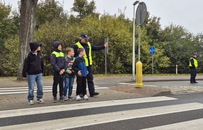 W październiku w naszej szkole odbyły się spotkania uczniów klas I–III z policjantami z Komisariatu Policji w Pasłęku. Podczas zajęć dzieci rozmawiały z funkcjonariuszami o bezpieczeństwie na drodze, uczyły się, jak prawidłowo zachowywać się na przejściu dla pieszych oraz jakie zasady są najważniejsze, by każdego dnia bezpiecznie dotrzeć do szkoły i wrócić do domu.
Uczniowie mieli okazję nie tylko posłuchać, ale również aktywnie ćwiczyć przechodzenie przez pasy pod czujnym okiem policjantów. Było edukacyjnie, ciekawie i bardzo praktycznie.
Serdecznie dziękujemy naszym gościom za poświęcony czas, zaangażowanie i cenne wskazówki, które pomogą naszym uczniom stać się prawdziwymi ekspertami od bezpieczeństwa na drodze.
