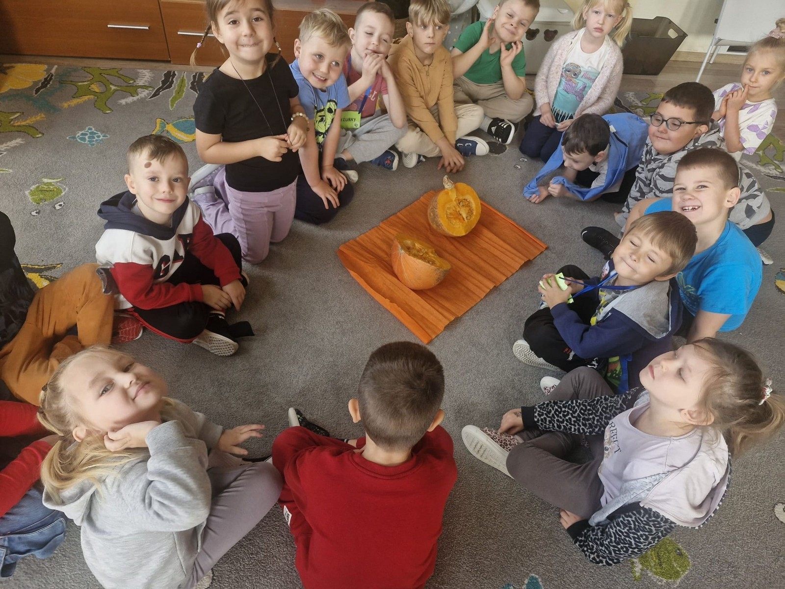 31 października nasze przedszkole zamieniło się w prawdziwą dyniową krainę! W salach królował kolor pomarańczowy, a wszędzie można było zobaczyć uśmiechnięte buzie dzieci i  dynie w różnych kształtach i rozmiarach.Przedszkolaki chętnie brały udział w zabawach muzyczno-ruchowych oraz zajęciach plastycznych z dynią w roli głównej.
Dzieci dowiedziały się, że dynia to nie tylko piękna ozdoba jesieni, ale również zdrowe i smaczne warzywo, z którego można przygotować wiele pysznych potraw.Na zakończenie dnia dzieci otrzymały dyniowe medale oraz pamiątkowe dyplomy,świadczące o ich udziale i zaangażowaniu w obchody tego święta.
To był dzień pełen radości, kolorów ,niezapomnianych wrażeń i jesiennej magii.
