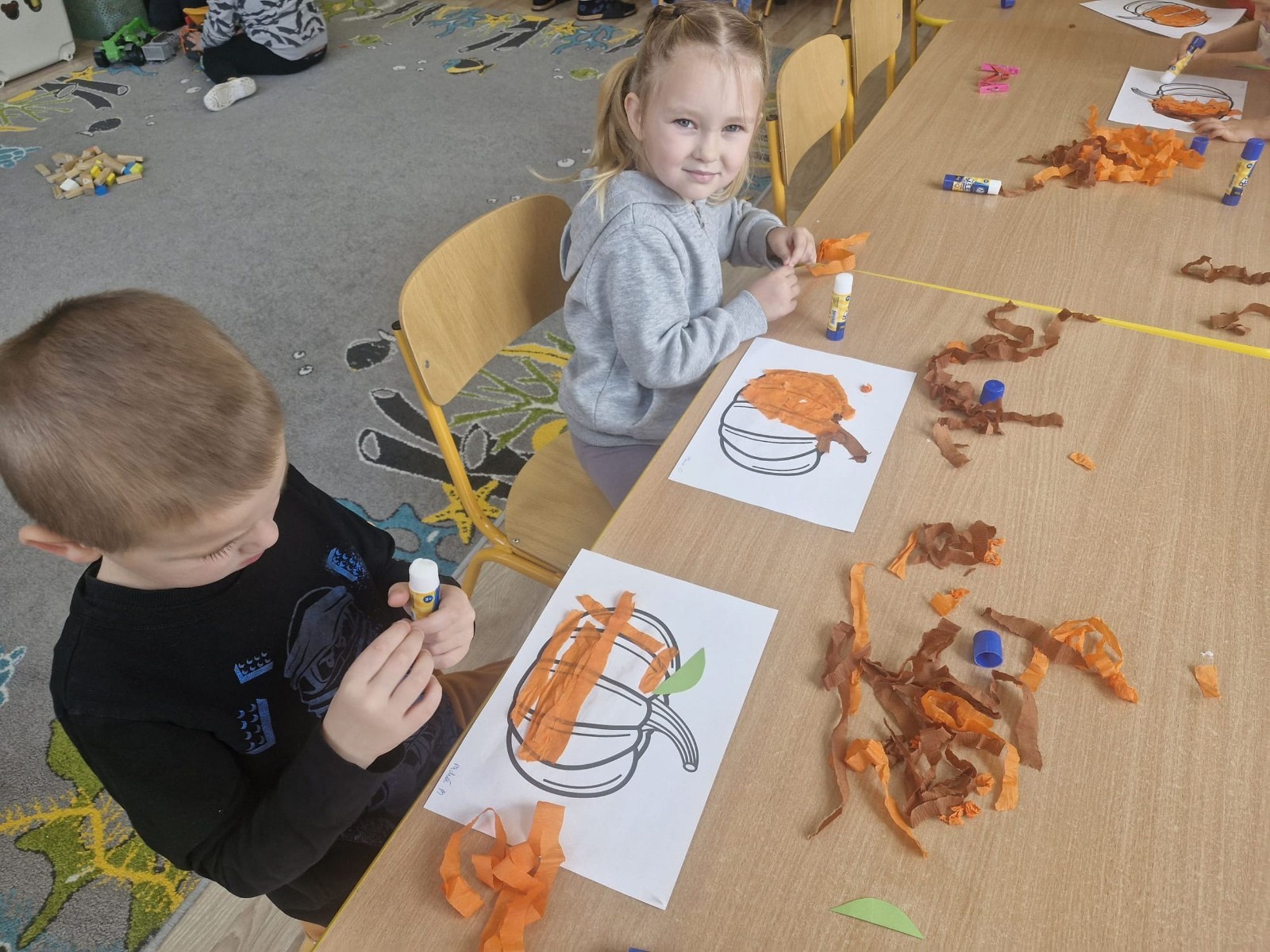 31 października nasze przedszkole zamieniło się w prawdziwą dyniową krainę! W salach królował kolor pomarańczowy, a wszędzie można było zobaczyć uśmiechnięte buzie dzieci i  dynie w różnych kształtach i rozmiarach.Przedszkolaki chętnie brały udział w zabawach muzyczno-ruchowych oraz zajęciach plastycznych z dynią w roli głównej.
Dzieci dowiedziały się, że dynia to nie tylko piękna ozdoba jesieni, ale również zdrowe i smaczne warzywo, z którego można przygotować wiele pysznych potraw.Na zakończenie dnia dzieci otrzymały dyniowe medale oraz pamiątkowe dyplomy,świadczące o ich udziale i zaangażowaniu w obchody tego święta.
To był dzień pełen radości, kolorów ,niezapomnianych wrażeń i jesiennej magii.
