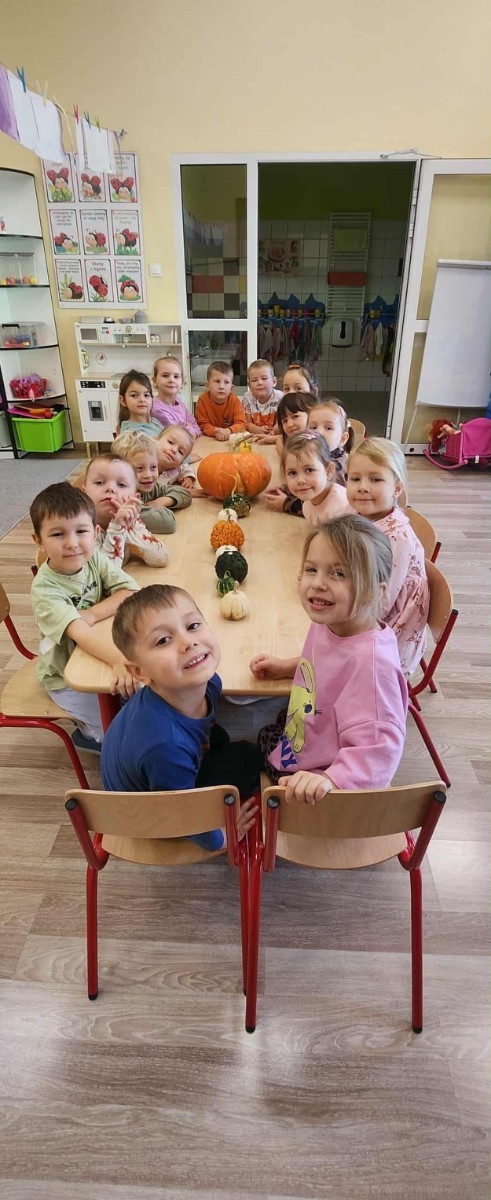 31 października nasze przedszkole zamieniło się w prawdziwą dyniową krainę! W salach królował kolor pomarańczowy, a wszędzie można było zobaczyć uśmiechnięte buzie dzieci i  dynie w różnych kształtach i rozmiarach.Przedszkolaki chętnie brały udział w zabawach muzyczno-ruchowych oraz zajęciach plastycznych z dynią w roli głównej.
Dzieci dowiedziały się, że dynia to nie tylko piękna ozdoba jesieni, ale również zdrowe i smaczne warzywo, z którego można przygotować wiele pysznych potraw.Na zakończenie dnia dzieci otrzymały dyniowe medale oraz pamiątkowe dyplomy,świadczące o ich udziale i zaangażowaniu w obchody tego święta.
To był dzień pełen radości, kolorów ,niezapomnianych wrażeń i jesiennej magii.
