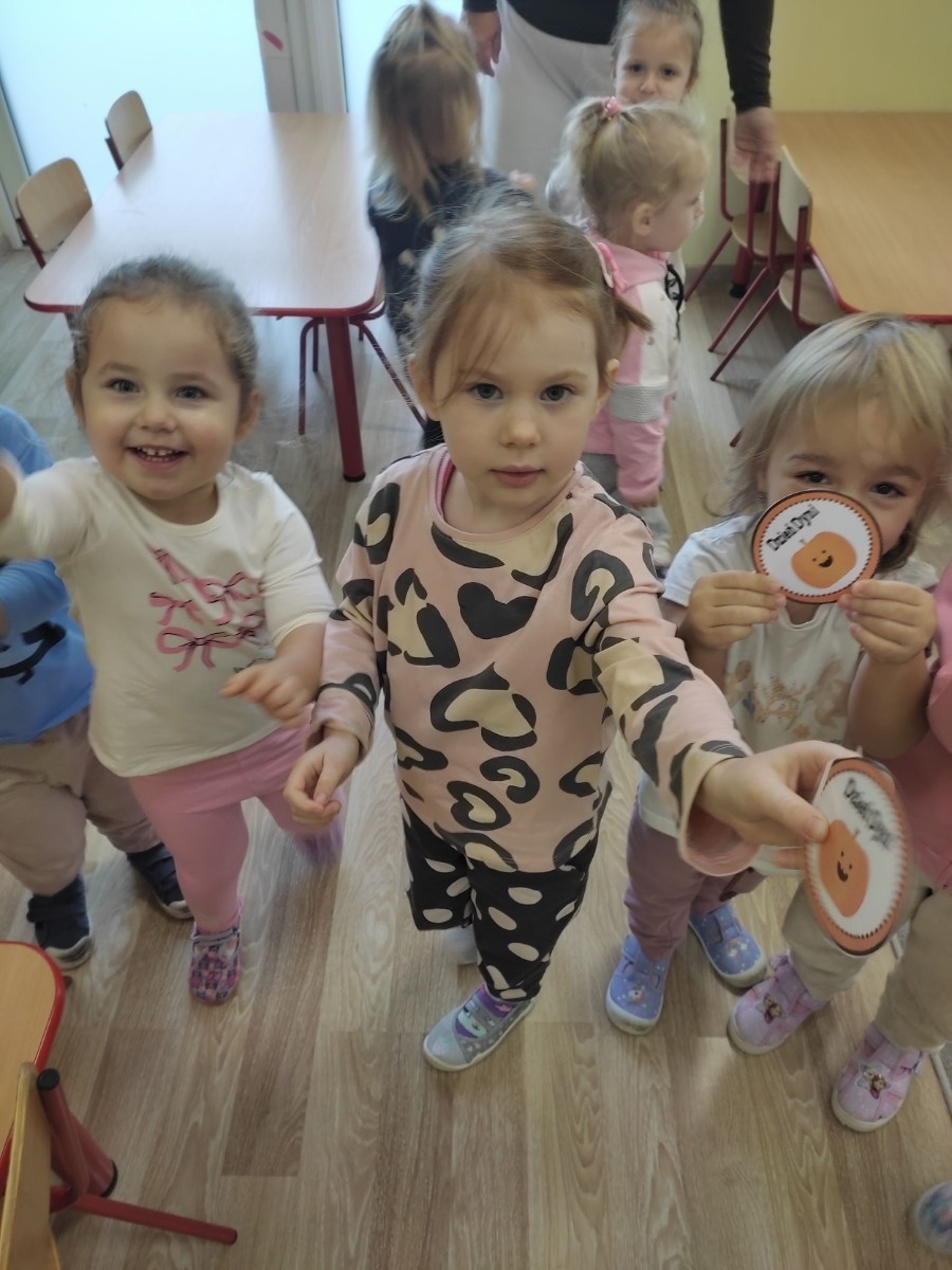 31 października nasze przedszkole zamieniło się w prawdziwą dyniową krainę! W salach królował kolor pomarańczowy, a wszędzie można było zobaczyć uśmiechnięte buzie dzieci i  dynie w różnych kształtach i rozmiarach.Przedszkolaki chętnie brały udział w zabawach muzyczno-ruchowych oraz zajęciach plastycznych z dynią w roli głównej.
Dzieci dowiedziały się, że dynia to nie tylko piękna ozdoba jesieni, ale również zdrowe i smaczne warzywo, z którego można przygotować wiele pysznych potraw.Na zakończenie dnia dzieci otrzymały dyniowe medale oraz pamiątkowe dyplomy,świadczące o ich udziale i zaangażowaniu w obchody tego święta.
To był dzień pełen radości, kolorów ,niezapomnianych wrażeń i jesiennej magii.

