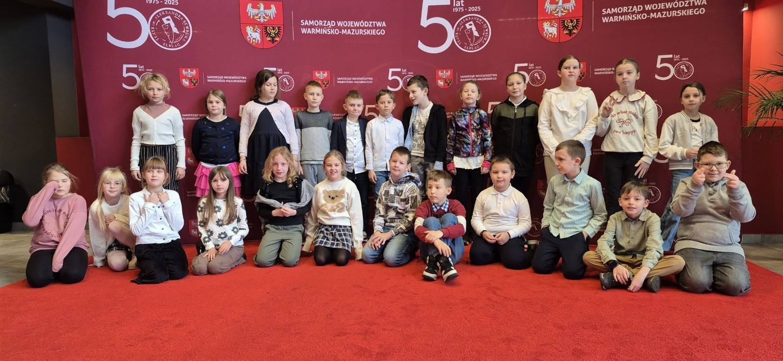 Uczniowie klas trzecich mieli dziś okazję uczestniczyć w wyjątkowym wydarzeniu artystycznym – odwiedzili Teatr im. Aleksandra Sewruka w Elblągu, gdzie obejrzeli spektakl „Dzieci z Bullerbyn”, przygotowany na podstawie uwielbianej przez kolejne pokolenia książki Astrid Lindgren.

Przedstawienie okazało się prawdziwą ucztą teatralną zarówno dla młodych widzów, jak i towarzyszących im nauczycieli. Twórcy spektaklu zadbali o to, by każda scena tętniła energią i kolorami. Na scenie pojawiło się wiele zabawnych historii i wzruszających momentów, które doskonale oddawały klimat klasycznej opowieści o przygodach dzieci z małej, szwedzkiej wioski.

W pamięci uczniów szczególnie zapisał się dynamiczny, pełen pozytywnej energii utwór muzyczny towarzyszący bohaterkom podczas powrotu z zakupów. Jego rytmiczna melodia wywołała szerokie uśmiechy na widowni i – jak przewidujemy – już wkrótce może stać się nieoficjalnym hitem szkolnych przerw.

Wizyta w teatrze była nie tylko okazją do świetnej zabawy, lecz także szansą na kontakt z kulturą w jej najpiękniejszym wydaniu. Uczniowie mogli zobaczyć, jak niezwykła potrafi być magia sceny i jak wiele emocji może przynieść profesjonalnie przygotowany spektakl. Dzisiejszy dzień z pewnością na długo pozostanie w pamięci naszych uczniów jako inspirujące spotkanie ze sztuką.