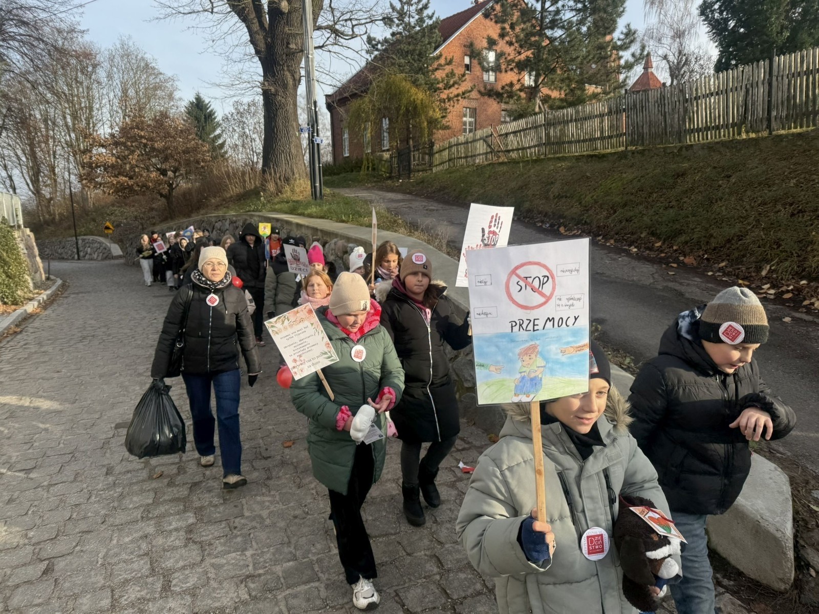 W środę 17.11.2025 nasza szkoła zorganizowała wyjątkowe wydarzenie, które było zaczątkiem podsumowania kampanii „Dzieciństwo bez Przemocy”. Dzień rozpoczął się od radosnego marszu, w którym dzieci grup przedszkolnych z wychowawczyniami oraz uczniowie wraz z nauczycielami przeszli ulicami naszego miasta. Podczas tego wydarzenia dzieci rozdawały mieszkańcom kolorowe maskotki, promując ideę bezpiecznego i szczęśliwego dzieciństwa.
Ważnym punktem dnia było spotkanie w Urzędzie Miasta z panią burmistrz, która serdecznie przyjęła naszych reprezentantów. Rozmowy dotyczyły dalszych działań na rzecz dzieci oraz wspierania inicjatyw mających na celu eliminację przemocy wśród najmłodszych.