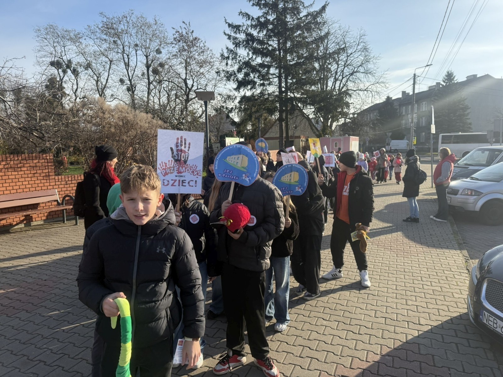 W środę 17.11.2025 nasza szkoła zorganizowała wyjątkowe wydarzenie, które było zaczątkiem podsumowania kampanii „Dzieciństwo bez Przemocy”. Dzień rozpoczął się od radosnego marszu, w którym dzieci grup przedszkolnych z wychowawczyniami oraz uczniowie wraz z nauczycielami przeszli ulicami naszego miasta. Podczas tego wydarzenia dzieci rozdawały mieszkańcom kolorowe maskotki, promując ideę bezpiecznego i szczęśliwego dzieciństwa.
Ważnym punktem dnia było spotkanie w Urzędzie Miasta z panią burmistrz, która serdecznie przyjęła naszych reprezentantów. Rozmowy dotyczyły dalszych działań na rzecz dzieci oraz wspierania inicjatyw mających na celu eliminację przemocy wśród najmłodszych.
