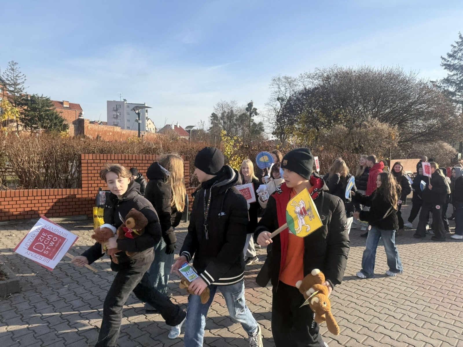 W środę 17.11.2025 nasza szkoła zorganizowała wyjątkowe wydarzenie, które było zaczątkiem podsumowania kampanii „Dzieciństwo bez Przemocy”. Dzień rozpoczął się od radosnego marszu, w którym dzieci grup przedszkolnych z wychowawczyniami oraz uczniowie wraz z nauczycielami przeszli ulicami naszego miasta. Podczas tego wydarzenia dzieci rozdawały mieszkańcom kolorowe maskotki, promując ideę bezpiecznego i szczęśliwego dzieciństwa.
Ważnym punktem dnia było spotkanie w Urzędzie Miasta z panią burmistrz, która serdecznie przyjęła naszych reprezentantów. Rozmowy dotyczyły dalszych działań na rzecz dzieci oraz wspierania inicjatyw mających na celu eliminację przemocy wśród najmłodszych.