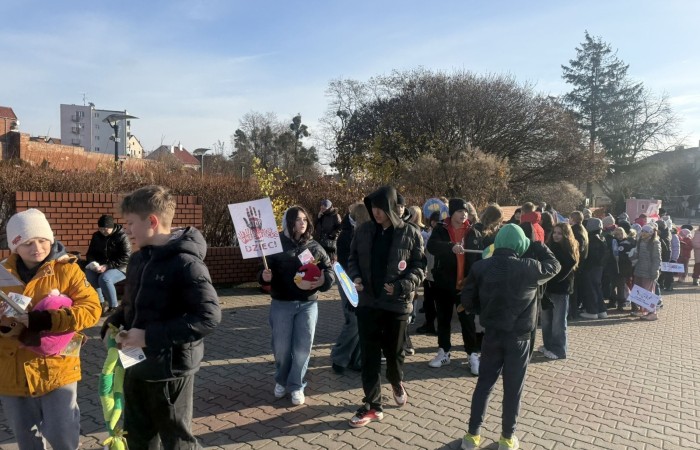 W środę 17.11.2025 nasza szkoła zorganizowała wyjątkowe wydarzenie, które było zaczątkiem podsumowania kampanii „Dzieciństwo bez Przemocy”. Dzień rozpoczął się od radosnego marszu, w którym dzieci grup przedszkolnych z wychowawczyniami oraz uczniowie wraz z nauczycielami przeszli ulicami naszego miasta. Podczas tego wydarzenia dzieci rozdawały mieszkańcom kolorowe maskotki, promując ideę bezpiecznego i szczęśliwego dzieciństwa.
Ważnym punktem dnia było spotkanie w Urzędzie Miasta z panią burmistrz, która serdecznie przyjęła naszych reprezentantów. Rozmowy dotyczyły dalszych działań na rzecz dzieci oraz wspierania inicjatyw mających na celu eliminację przemocy wśród najmłodszych.