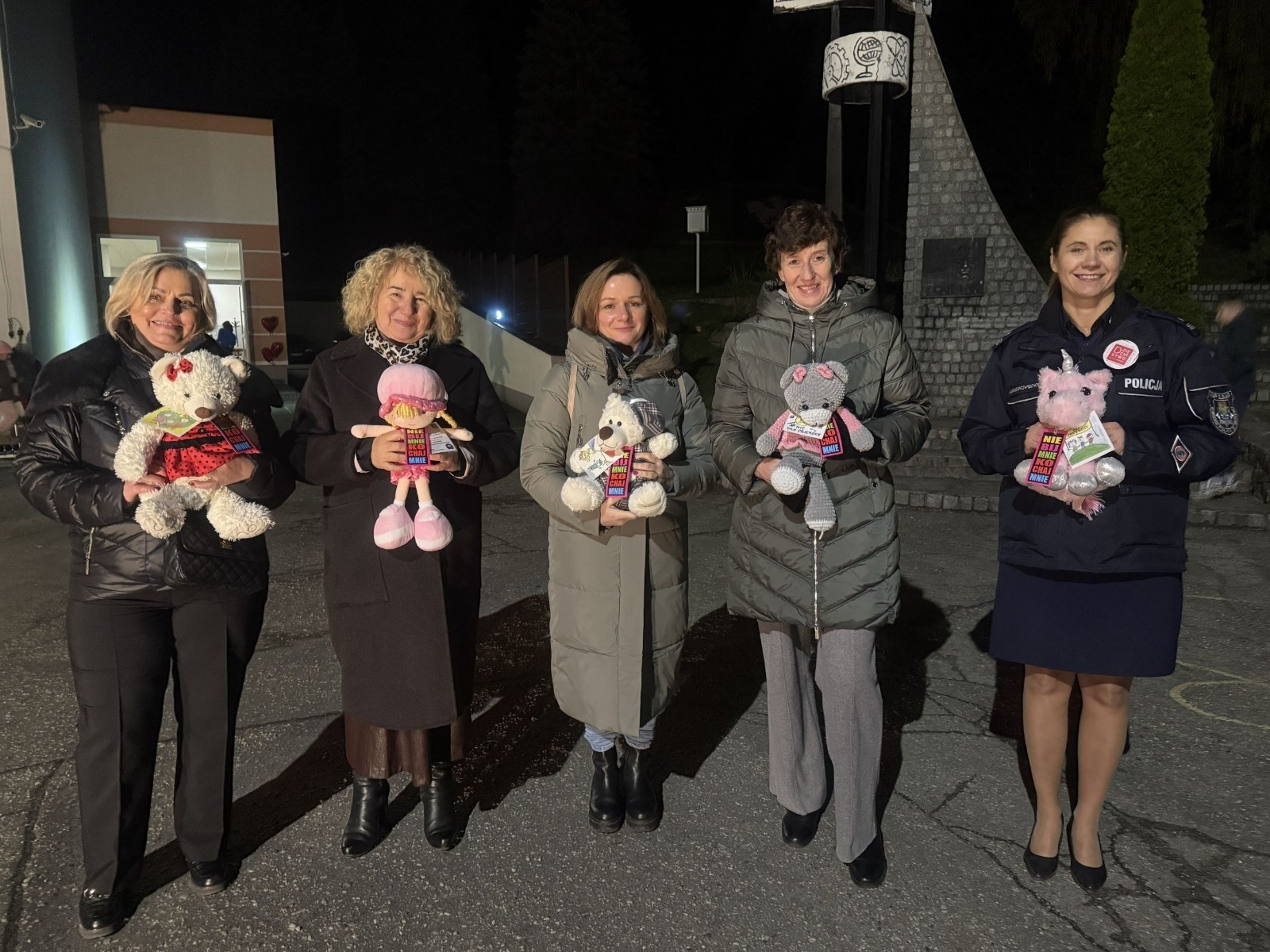 O godzinie 17:00 pod szkołą rozpoczęła się impreza, która zgromadziła około 200 osób. Szkoła została podświetlona na czerwono, co symbolizowało naszą jedność w walce z przemocą. Był to akcent podsumowujący nasze wcześ iej sze  działania w ramach Kampanii Ogólnopolskiej „Dzieciństwo bez Przemocy”. Od października uczniowie uczestniczyli w lekcjach online przygotowanych przez Fundację Dajemy Dzieciom Siłę. Rodzice również zostali objęci wsparciem w postaci webinaru online ww. fudacji.
Uczestnicy mogli wziąć udział w wspólnym śpiewaniu, quizie wiedzy o przemocy oraz tworzeniu „kamieni mocy” – symboli pozytywnej energii i wsparcia. Dodatkowo, w ramach konkursów, przyznano nagrody ufundowane przez Urząd Miejski w Pasłęku.
Ten cudowny czas umilił nam smaczny poczęstunek, w tym grochówka, pizza i ciasta, gorąca kawa i herbatka przygotowany przez panie kucharki i rodziców.
W wydarzeniu uczestniczyli również zaproszeni goście, w tym Burmistrz Pasłęka – pani Elżbieta Wasiuk,  podinspektor KP Pasłęk – pani Agnieszka Bielewicz - Piechowiak oraz przedstawiciel Kuratorium Oświaty w Elblągu – pani Teresa Bednarz, którzy wspierają nasze działania. Ich obecność była dowodem na to, jak ważna jest współpraca lokalnej społeczności w walce z przemocą wobec dzieci. Dziękujemy wszystkim, którzy wzięli udział w tym wyjątkowym dniu oraz przyczynili się do jego organizacji. Razem możemy stworzyć bezpieczne i przyjazne środowisko dla naszych dzieci!
