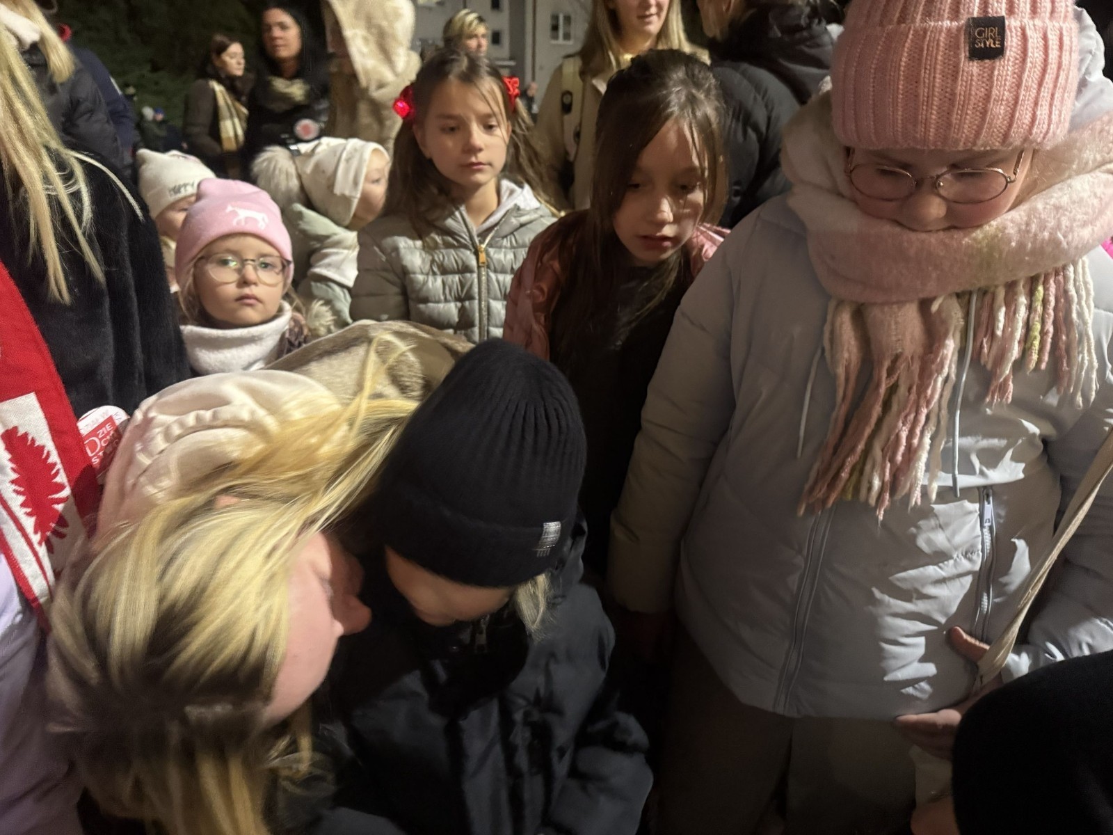 O godzinie 17:00 pod szkołą rozpoczęła się impreza, która zgromadziła około 200 osób. Szkoła została podświetlona na czerwono, co symbolizowało naszą jedność w walce z przemocą. Był to akcent podsumowujący nasze wcześ iej sze  działania w ramach Kampanii Ogólnopolskiej „Dzieciństwo bez Przemocy”. Od października uczniowie uczestniczyli w lekcjach online przygotowanych przez Fundację Dajemy Dzieciom Siłę. Rodzice również zostali objęci wsparciem w postaci webinaru online ww. fudacji.
Uczestnicy mogli wziąć udział w wspólnym śpiewaniu, quizie wiedzy o przemocy oraz tworzeniu „kamieni mocy” – symboli pozytywnej energii i wsparcia. Dodatkowo, w ramach konkursów, przyznano nagrody ufundowane przez Urząd Miejski w Pasłęku.
Ten cudowny czas umilił nam smaczny poczęstunek, w tym grochówka, pizza i ciasta, gorąca kawa i herbatka przygotowany przez panie kucharki i rodziców.
W wydarzeniu uczestniczyli również zaproszeni goście, w tym Burmistrz Pasłęka – pani Elżbieta Wasiuk,  podinspektor KP Pasłęk – pani Agnieszka Bielewicz - Piechowiak oraz przedstawiciel Kuratorium Oświaty w Elblągu – pani Teresa Bednarz, którzy wspierają nasze działania. Ich obecność była dowodem na to, jak ważna jest współpraca lokalnej społeczności w walce z przemocą wobec dzieci. Dziękujemy wszystkim, którzy wzięli udział w tym wyjątkowym dniu oraz przyczynili się do jego organizacji. Razem możemy stworzyć bezpieczne i przyjazne środowisko dla naszych dzieci!
