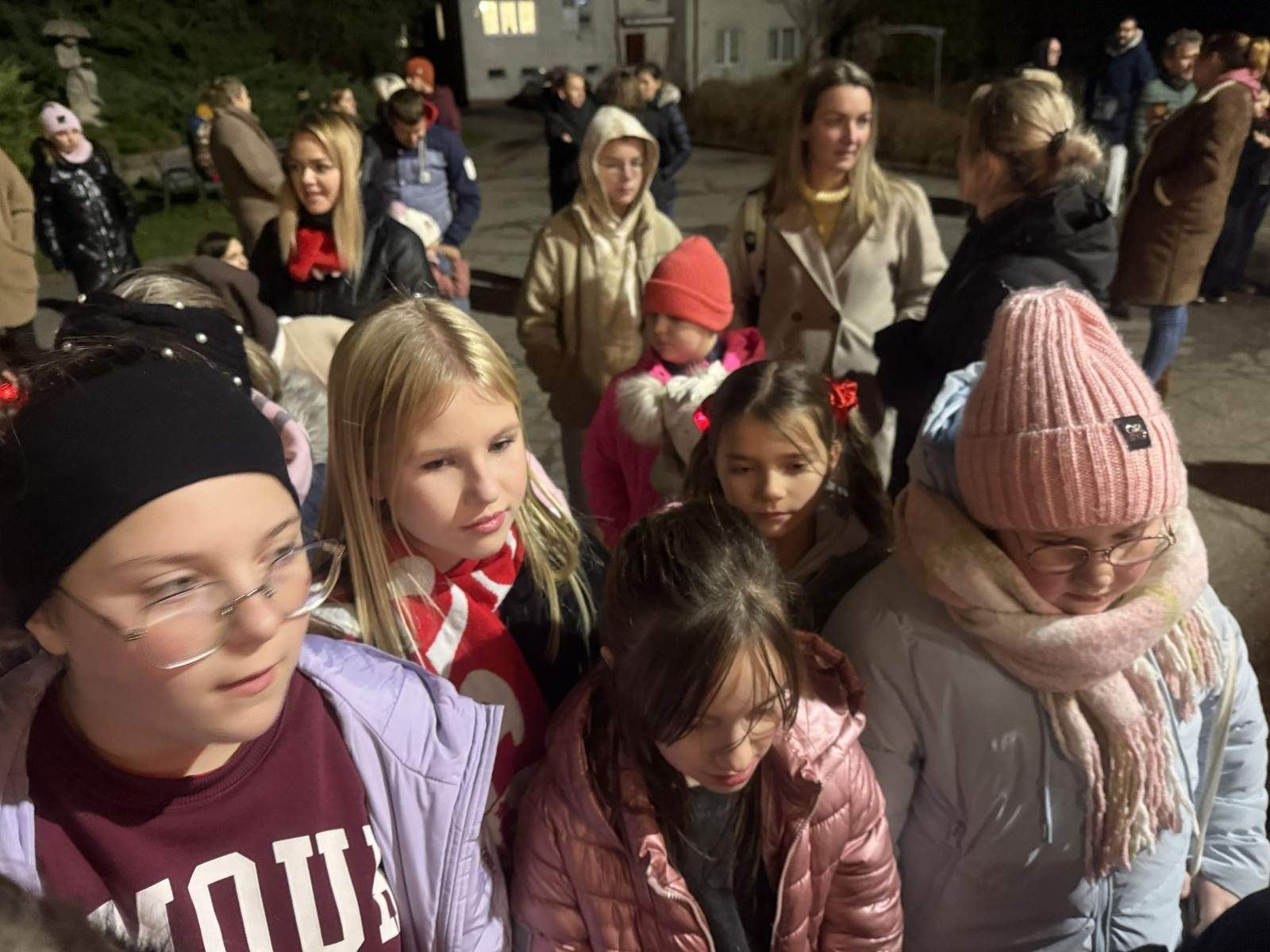 O godzinie 17:00 pod szkołą rozpoczęła się impreza, która zgromadziła około 200 osób. Szkoła została podświetlona na czerwono, co symbolizowało naszą jedność w walce z przemocą. Był to akcent podsumowujący nasze wcześ iej sze  działania w ramach Kampanii Ogólnopolskiej „Dzieciństwo bez Przemocy”. Od października uczniowie uczestniczyli w lekcjach online przygotowanych przez Fundację Dajemy Dzieciom Siłę. Rodzice również zostali objęci wsparciem w postaci webinaru online ww. fudacji.
Uczestnicy mogli wziąć udział w wspólnym śpiewaniu, quizie wiedzy o przemocy oraz tworzeniu „kamieni mocy” – symboli pozytywnej energii i wsparcia. Dodatkowo, w ramach konkursów, przyznano nagrody ufundowane przez Urząd Miejski w Pasłęku.
Ten cudowny czas umilił nam smaczny poczęstunek, w tym grochówka, pizza i ciasta, gorąca kawa i herbatka przygotowany przez panie kucharki i rodziców.
W wydarzeniu uczestniczyli również zaproszeni goście, w tym Burmistrz Pasłęka – pani Elżbieta Wasiuk,  podinspektor KP Pasłęk – pani Agnieszka Bielewicz - Piechowiak oraz przedstawiciel Kuratorium Oświaty w Elblągu – pani Teresa Bednarz, którzy wspierają nasze działania. Ich obecność była dowodem na to, jak ważna jest współpraca lokalnej społeczności w walce z przemocą wobec dzieci. Dziękujemy wszystkim, którzy wzięli udział w tym wyjątkowym dniu oraz przyczynili się do jego organizacji. Razem możemy stworzyć bezpieczne i przyjazne środowisko dla naszych dzieci!
