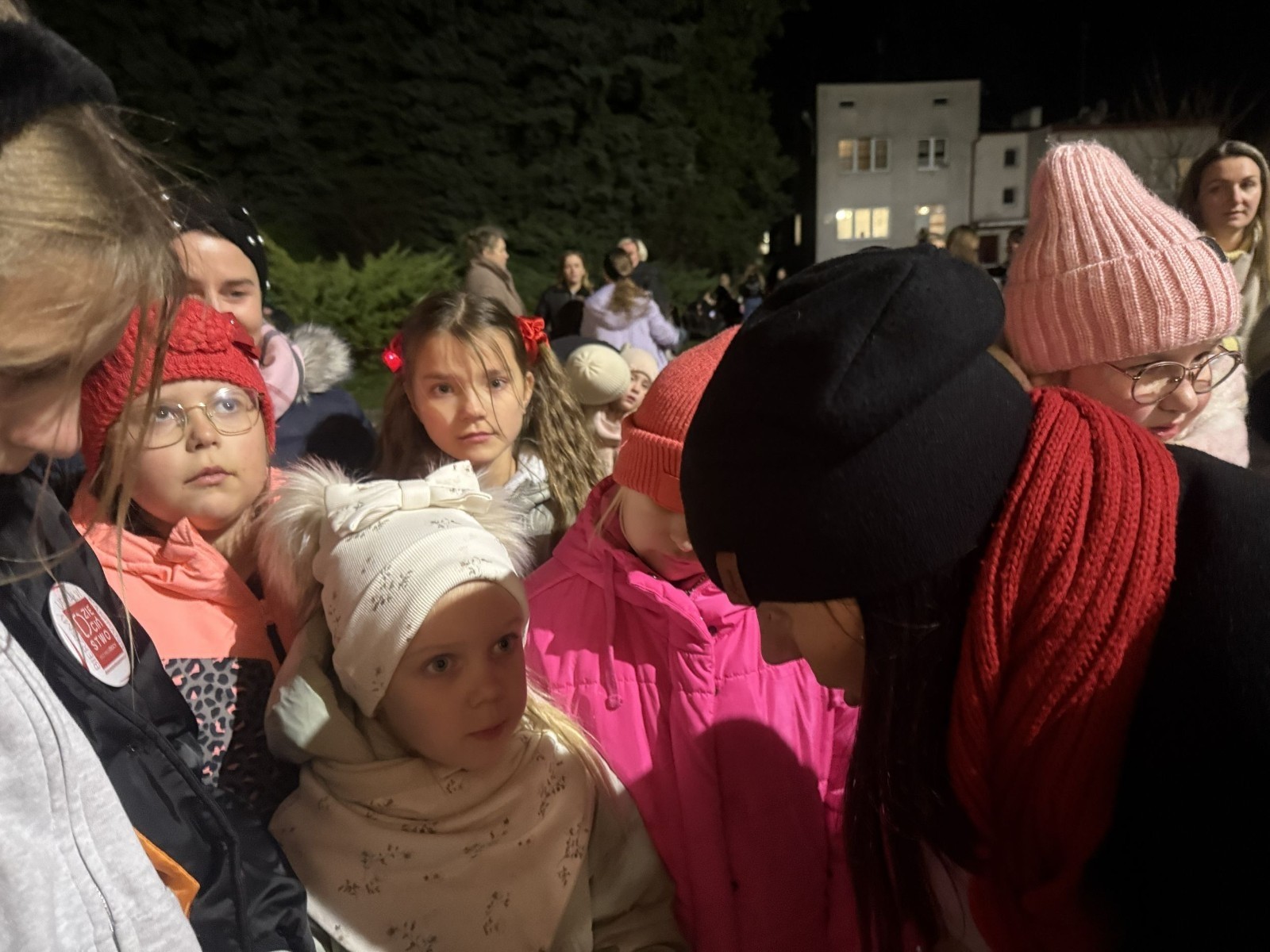 O godzinie 17:00 pod szkołą rozpoczęła się impreza, która zgromadziła około 200 osób. Szkoła została podświetlona na czerwono, co symbolizowało naszą jedność w walce z przemocą. Był to akcent podsumowujący nasze wcześ iej sze  działania w ramach Kampanii Ogólnopolskiej „Dzieciństwo bez Przemocy”. Od października uczniowie uczestniczyli w lekcjach online przygotowanych przez Fundację Dajemy Dzieciom Siłę. Rodzice również zostali objęci wsparciem w postaci webinaru online ww. fudacji.
Uczestnicy mogli wziąć udział w wspólnym śpiewaniu, quizie wiedzy o przemocy oraz tworzeniu „kamieni mocy” – symboli pozytywnej energii i wsparcia. Dodatkowo, w ramach konkursów, przyznano nagrody ufundowane przez Urząd Miejski w Pasłęku.
Ten cudowny czas umilił nam smaczny poczęstunek, w tym grochówka, pizza i ciasta, gorąca kawa i herbatka przygotowany przez panie kucharki i rodziców.
W wydarzeniu uczestniczyli również zaproszeni goście, w tym Burmistrz Pasłęka – pani Elżbieta Wasiuk,  podinspektor KP Pasłęk – pani Agnieszka Bielewicz - Piechowiak oraz przedstawiciel Kuratorium Oświaty w Elblągu – pani Teresa Bednarz, którzy wspierają nasze działania. Ich obecność była dowodem na to, jak ważna jest współpraca lokalnej społeczności w walce z przemocą wobec dzieci. Dziękujemy wszystkim, którzy wzięli udział w tym wyjątkowym dniu oraz przyczynili się do jego organizacji. Razem możemy stworzyć bezpieczne i przyjazne środowisko dla naszych dzieci!
