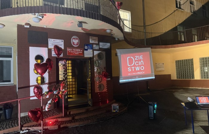 O godzinie 17:00 pod szkołą rozpoczęła się impreza, która zgromadziła około 200 osób. Szkoła została podświetlona na czerwono, co symbolizowało naszą jedność w walce z przemocą. Był to akcent podsumowujący nasze wcześ iej sze  działania w ramach Kampanii Ogólnopolskiej „Dzieciństwo bez Przemocy”. Od października uczniowie uczestniczyli w lekcjach online przygotowanych przez Fundację Dajemy Dzieciom Siłę. Rodzice również zostali objęci wsparciem w postaci webinaru online ww. fudacji.
Uczestnicy mogli wziąć udział w wspólnym śpiewaniu, quizie wiedzy o przemocy oraz tworzeniu „kamieni mocy” – symboli pozytywnej energii i wsparcia. Dodatkowo, w ramach konkursów, przyznano nagrody ufundowane przez Urząd Miejski w Pasłęku.
Ten cudowny czas umilił nam smaczny poczęstunek, w tym grochówka, pizza i ciasta, gorąca kawa i herbatka przygotowany przez panie kucharki i rodziców.
W wydarzeniu uczestniczyli również zaproszeni goście, w tym Burmistrz Pasłęka – pani Elżbieta Wasiuk,  podinspektor KP Pasłęk – pani Agnieszka Bielewicz - Piechowiak oraz przedstawiciel Kuratorium Oświaty w Elblągu – pani Teresa Bednarz, którzy wspierają nasze działania. Ich obecność była dowodem na to, jak ważna jest współpraca lokalnej społeczności w walce z przemocą wobec dzieci. Dziękujemy wszystkim, którzy wzięli udział w tym wyjątkowym dniu oraz przyczynili się do jego organizacji. Razem możemy stworzyć bezpieczne i przyjazne środowisko dla naszych dzieci!
