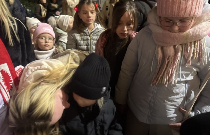 O godzinie 17:00 pod szkołą rozpoczęła się impreza, która zgromadziła około 200 osób. Szkoła została podświetlona na czerwono, co symbolizowało naszą jedność w walce z przemocą. Był to akcent podsumowujący nasze wcześ iej sze  działania w ramach Kampanii Ogólnopolskiej „Dzieciństwo bez Przemocy”. Od października uczniowie uczestniczyli w lekcjach online przygotowanych przez Fundację Dajemy Dzieciom Siłę. Rodzice również zostali objęci wsparciem w postaci webinaru online ww. fudacji.
Uczestnicy mogli wziąć udział w wspólnym śpiewaniu, quizie wiedzy o przemocy oraz tworzeniu „kamieni mocy” – symboli pozytywnej energii i wsparcia. Dodatkowo, w ramach konkursów, przyznano nagrody ufundowane przez Urząd Miejski w Pasłęku.
Ten cudowny czas umilił nam smaczny poczęstunek, w tym grochówka, pizza i ciasta, gorąca kawa i herbatka przygotowany przez panie kucharki i rodziców.
W wydarzeniu uczestniczyli również zaproszeni goście, w tym Burmistrz Pasłęka – pani Elżbieta Wasiuk,  podinspektor KP Pasłęk – pani Agnieszka Bielewicz - Piechowiak oraz przedstawiciel Kuratorium Oświaty w Elblągu – pani Teresa Bednarz, którzy wspierają nasze działania. Ich obecność była dowodem na to, jak ważna jest współpraca lokalnej społeczności w walce z przemocą wobec dzieci. Dziękujemy wszystkim, którzy wzięli udział w tym wyjątkowym dniu oraz przyczynili się do jego organizacji. Razem możemy stworzyć bezpieczne i przyjazne środowisko dla naszych dzieci!
