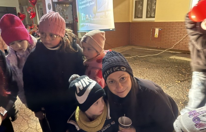 O godzinie 17:00 pod szkołą rozpoczęła się impreza, która zgromadziła około 200 osób. Szkoła została podświetlona na czerwono, co symbolizowało naszą jedność w walce z przemocą. Był to akcent podsumowujący nasze wcześ iej sze  działania w ramach Kampanii Ogólnopolskiej „Dzieciństwo bez Przemocy”. Od października uczniowie uczestniczyli w lekcjach online przygotowanych przez Fundację Dajemy Dzieciom Siłę. Rodzice również zostali objęci wsparciem w postaci webinaru online ww. fudacji.
Uczestnicy mogli wziąć udział w wspólnym śpiewaniu, quizie wiedzy o przemocy oraz tworzeniu „kamieni mocy” – symboli pozytywnej energii i wsparcia. Dodatkowo, w ramach konkursów, przyznano nagrody ufundowane przez Urząd Miejski w Pasłęku.
Ten cudowny czas umilił nam smaczny poczęstunek, w tym grochówka, pizza i ciasta, gorąca kawa i herbatka przygotowany przez panie kucharki i rodziców.
W wydarzeniu uczestniczyli również zaproszeni goście, w tym Burmistrz Pasłęka – pani Elżbieta Wasiuk,  podinspektor KP Pasłęk – pani Agnieszka Bielewicz - Piechowiak oraz przedstawiciel Kuratorium Oświaty w Elblągu – pani Teresa Bednarz, którzy wspierają nasze działania. Ich obecność była dowodem na to, jak ważna jest współpraca lokalnej społeczności w walce z przemocą wobec dzieci. Dziękujemy wszystkim, którzy wzięli udział w tym wyjątkowym dniu oraz przyczynili się do jego organizacji. Razem możemy stworzyć bezpieczne i przyjazne środowisko dla naszych dzieci!
