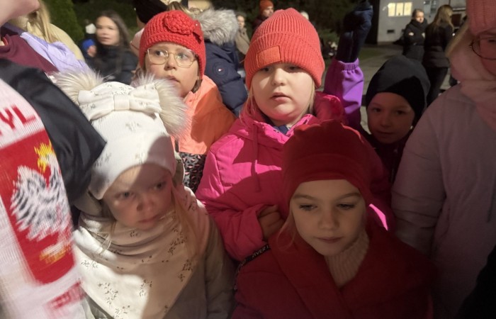 O godzinie 17:00 pod szkołą rozpoczęła się impreza, która zgromadziła około 200 osób. Szkoła została podświetlona na czerwono, co symbolizowało naszą jedność w walce z przemocą. Był to akcent podsumowujący nasze wcześ iej sze  działania w ramach Kampanii Ogólnopolskiej „Dzieciństwo bez Przemocy”. Od października uczniowie uczestniczyli w lekcjach online przygotowanych przez Fundację Dajemy Dzieciom Siłę. Rodzice również zostali objęci wsparciem w postaci webinaru online ww. fudacji.
Uczestnicy mogli wziąć udział w wspólnym śpiewaniu, quizie wiedzy o przemocy oraz tworzeniu „kamieni mocy” – symboli pozytywnej energii i wsparcia. Dodatkowo, w ramach konkursów, przyznano nagrody ufundowane przez Urząd Miejski w Pasłęku.
Ten cudowny czas umilił nam smaczny poczęstunek, w tym grochówka, pizza i ciasta, gorąca kawa i herbatka przygotowany przez panie kucharki i rodziców.
W wydarzeniu uczestniczyli również zaproszeni goście, w tym Burmistrz Pasłęka – pani Elżbieta Wasiuk,  podinspektor KP Pasłęk – pani Agnieszka Bielewicz - Piechowiak oraz przedstawiciel Kuratorium Oświaty w Elblągu – pani Teresa Bednarz, którzy wspierają nasze działania. Ich obecność była dowodem na to, jak ważna jest współpraca lokalnej społeczności w walce z przemocą wobec dzieci. Dziękujemy wszystkim, którzy wzięli udział w tym wyjątkowym dniu oraz przyczynili się do jego organizacji. Razem możemy stworzyć bezpieczne i przyjazne środowisko dla naszych dzieci!
