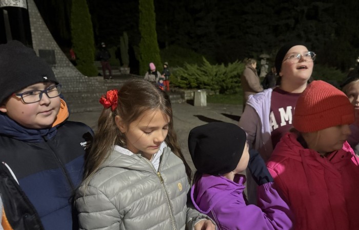 O godzinie 17:00 pod szkołą rozpoczęła się impreza, która zgromadziła około 200 osób. Szkoła została podświetlona na czerwono, co symbolizowało naszą jedność w walce z przemocą. Był to akcent podsumowujący nasze wcześ iej sze  działania w ramach Kampanii Ogólnopolskiej „Dzieciństwo bez Przemocy”. Od października uczniowie uczestniczyli w lekcjach online przygotowanych przez Fundację Dajemy Dzieciom Siłę. Rodzice również zostali objęci wsparciem w postaci webinaru online ww. fudacji.
Uczestnicy mogli wziąć udział w wspólnym śpiewaniu, quizie wiedzy o przemocy oraz tworzeniu „kamieni mocy” – symboli pozytywnej energii i wsparcia. Dodatkowo, w ramach konkursów, przyznano nagrody ufundowane przez Urząd Miejski w Pasłęku.
Ten cudowny czas umilił nam smaczny poczęstunek, w tym grochówka, pizza i ciasta, gorąca kawa i herbatka przygotowany przez panie kucharki i rodziców.
W wydarzeniu uczestniczyli również zaproszeni goście, w tym Burmistrz Pasłęka – pani Elżbieta Wasiuk,  podinspektor KP Pasłęk – pani Agnieszka Bielewicz - Piechowiak oraz przedstawiciel Kuratorium Oświaty w Elblągu – pani Teresa Bednarz, którzy wspierają nasze działania. Ich obecność była dowodem na to, jak ważna jest współpraca lokalnej społeczności w walce z przemocą wobec dzieci. Dziękujemy wszystkim, którzy wzięli udział w tym wyjątkowym dniu oraz przyczynili się do jego organizacji. Razem możemy stworzyć bezpieczne i przyjazne środowisko dla naszych dzieci!
