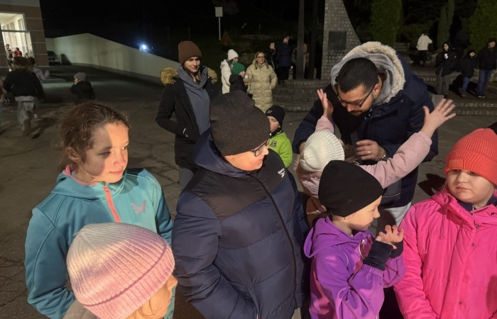 O godzinie 17:00 pod szkołą rozpoczęła się impreza, która zgromadziła około 200 osób. Szkoła została podświetlona na czerwono, co symbolizowało naszą jedność w walce z przemocą. Był to akcent podsumowujący nasze wcześ iej sze  działania w ramach Kampanii Ogólnopolskiej „Dzieciństwo bez Przemocy”. Od października uczniowie uczestniczyli w lekcjach online przygotowanych przez Fundację Dajemy Dzieciom Siłę. Rodzice również zostali objęci wsparciem w postaci webinaru online ww. fudacji.
Uczestnicy mogli wziąć udział w wspólnym śpiewaniu, quizie wiedzy o przemocy oraz tworzeniu „kamieni mocy” – symboli pozytywnej energii i wsparcia. Dodatkowo, w ramach konkursów, przyznano nagrody ufundowane przez Urząd Miejski w Pasłęku.
Ten cudowny czas umilił nam smaczny poczęstunek, w tym grochówka, pizza i ciasta, gorąca kawa i herbatka przygotowany przez panie kucharki i rodziców.
W wydarzeniu uczestniczyli również zaproszeni goście, w tym Burmistrz Pasłęka – pani Elżbieta Wasiuk,  podinspektor KP Pasłęk – pani Agnieszka Bielewicz - Piechowiak oraz przedstawiciel Kuratorium Oświaty w Elblągu – pani Teresa Bednarz, którzy wspierają nasze działania. Ich obecność była dowodem na to, jak ważna jest współpraca lokalnej społeczności w walce z przemocą wobec dzieci. Dziękujemy wszystkim, którzy wzięli udział w tym wyjątkowym dniu oraz przyczynili się do jego organizacji. Razem możemy stworzyć bezpieczne i przyjazne środowisko dla naszych dzieci!
