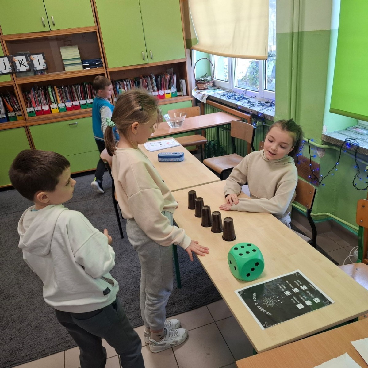 W tym roku Andrzejki w naszej szkole były pełne magii, radości i uśmiechu. Uczniowie klas trzecich przygotowali dla pierwszaków wyjątkowe wróżby i zabawy, dzięki którym mali uczestnicy mogli poczuć prawdziwą andrzejkową atmosferę. Nie zabrakło tradycyjnych wróżb, takich jak serca z imionami, magiczne kubeczki czy karty, a także mnóstwa śmiechu i wspólnej zabawy. Było kolorowo, wesoło i… trochę tajemniczo.
Serdeczne podziękowania dla naszych starszych uczniów za kreatywność i świetną zabawę, a także dla pierwszaków za aktywny udział w andrzejkowych atrakcjach. To był naprawdę magiczny dzień.