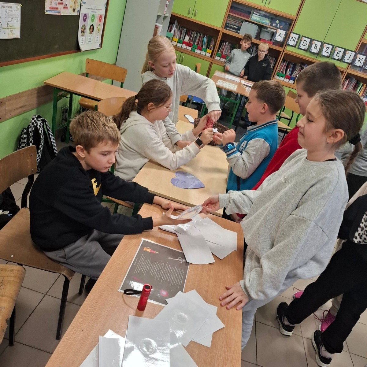 W tym roku Andrzejki w naszej szkole były pełne magii, radości i uśmiechu. Uczniowie klas trzecich przygotowali dla pierwszaków wyjątkowe wróżby i zabawy, dzięki którym mali uczestnicy mogli poczuć prawdziwą andrzejkową atmosferę. Nie zabrakło tradycyjnych wróżb, takich jak serca z imionami, magiczne kubeczki czy karty, a także mnóstwa śmiechu i wspólnej zabawy. Było kolorowo, wesoło i… trochę tajemniczo.
Serdeczne podziękowania dla naszych starszych uczniów za kreatywność i świetną zabawę, a także dla pierwszaków za aktywny udział w andrzejkowych atrakcjach. To był naprawdę magiczny dzień.