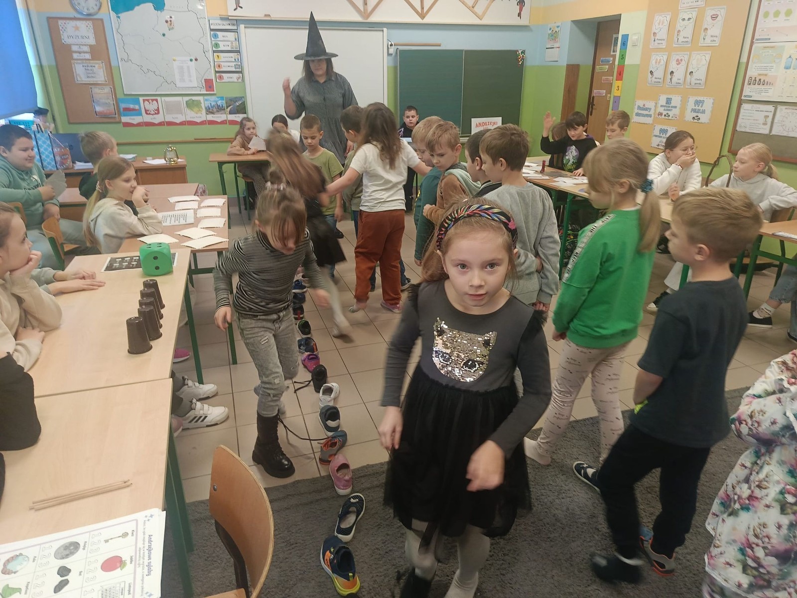 W tym roku Andrzejki w naszej szkole były pełne magii, radości i uśmiechu. Uczniowie klas trzecich przygotowali dla pierwszaków wyjątkowe wróżby i zabawy, dzięki którym mali uczestnicy mogli poczuć prawdziwą andrzejkową atmosferę. Nie zabrakło tradycyjnych wróżb, takich jak serca z imionami, magiczne kubeczki czy karty, a także mnóstwa śmiechu i wspólnej zabawy. Było kolorowo, wesoło i… trochę tajemniczo.
Serdeczne podziękowania dla naszych starszych uczniów za kreatywność i świetną zabawę, a także dla pierwszaków za aktywny udział w andrzejkowych atrakcjach. To był naprawdę magiczny dzień.