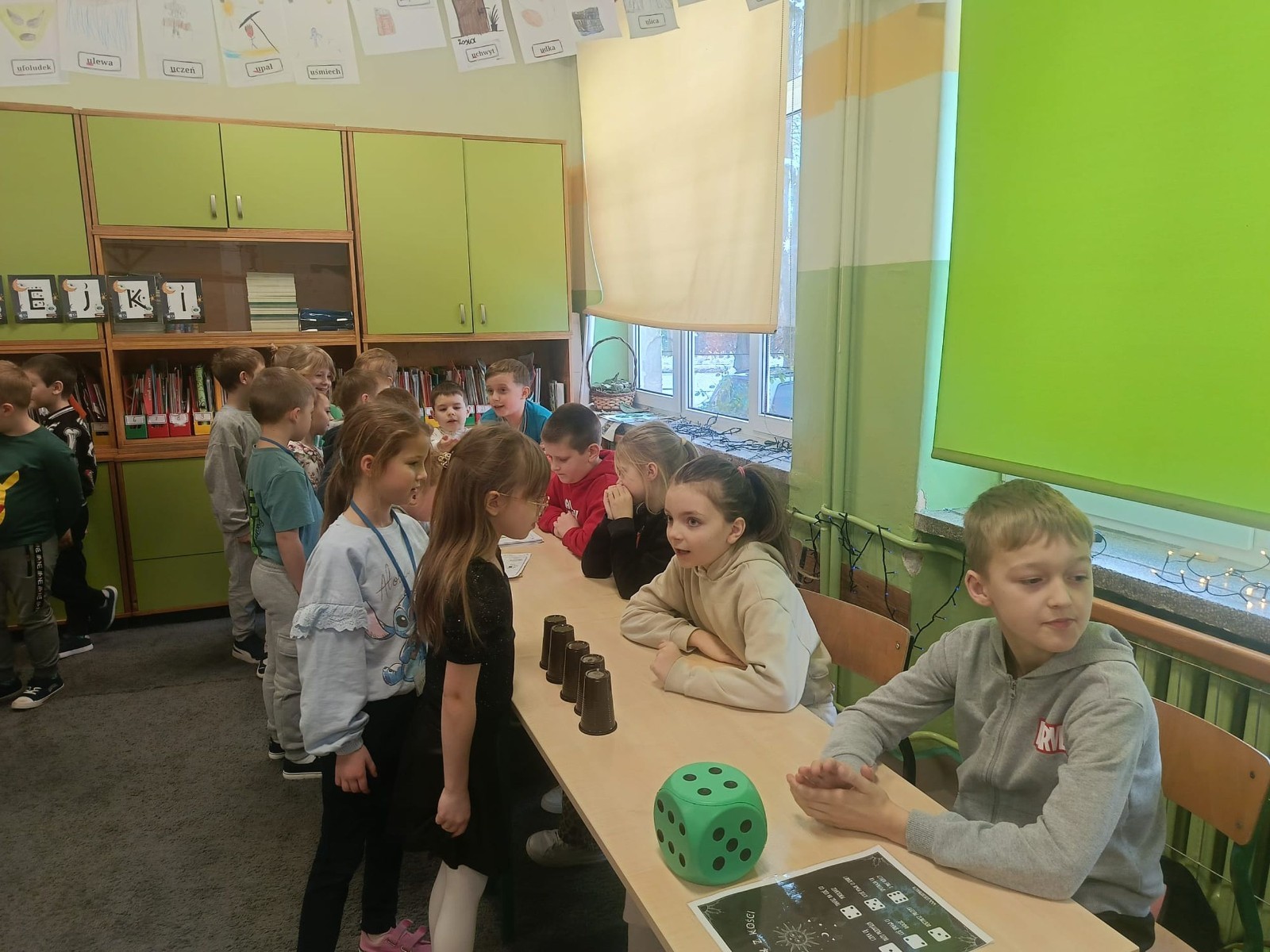 W tym roku Andrzejki w naszej szkole były pełne magii, radości i uśmiechu. Uczniowie klas trzecich przygotowali dla pierwszaków wyjątkowe wróżby i zabawy, dzięki którym mali uczestnicy mogli poczuć prawdziwą andrzejkową atmosferę. Nie zabrakło tradycyjnych wróżb, takich jak serca z imionami, magiczne kubeczki czy karty, a także mnóstwa śmiechu i wspólnej zabawy. Było kolorowo, wesoło i… trochę tajemniczo.
Serdeczne podziękowania dla naszych starszych uczniów za kreatywność i świetną zabawę, a także dla pierwszaków za aktywny udział w andrzejkowych atrakcjach. To był naprawdę magiczny dzień.